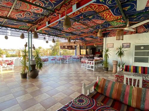 um restaurante com tectos coloridos, mesas e cadeiras em El Gezira Hotel em Luxor
