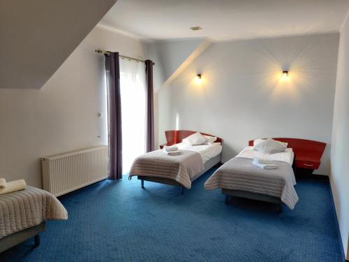 a hotel room with two beds and a window at Sosnowe Zacisze Barszczewo in Choroszcz