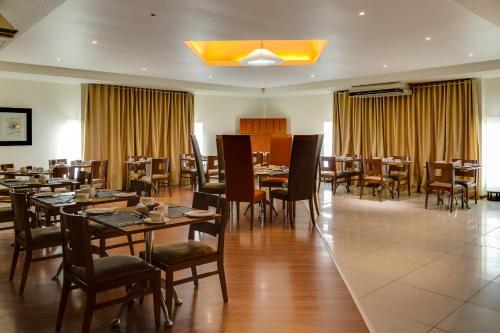 a dining room with wooden tables and chairs at The Oasis in Upington