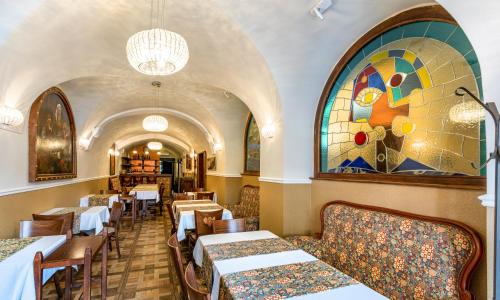 a restaurant with tables and chairs and a stained glass window at Residence U Černého Orla in Prague