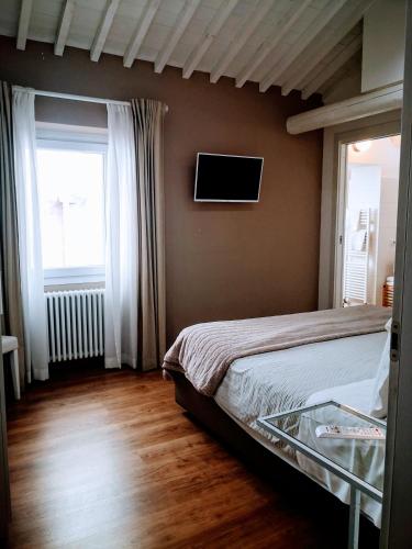 a bedroom with a bed and a tv on the wall at La Maison De Charme ROOMS in Verona