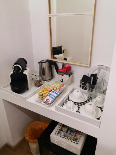 a white shelf with dishes and a mirror at La Maison De Charme ROOMS in Verona