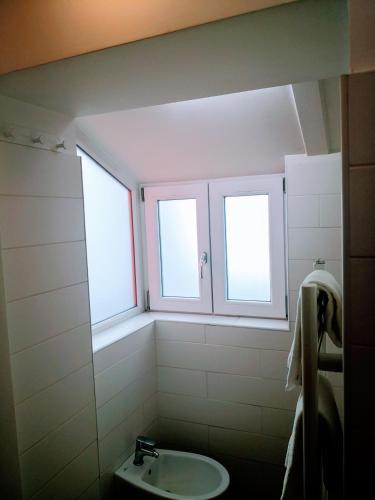 a bathroom with two windows and a sink at La Maison De Charme ROOMS in Verona