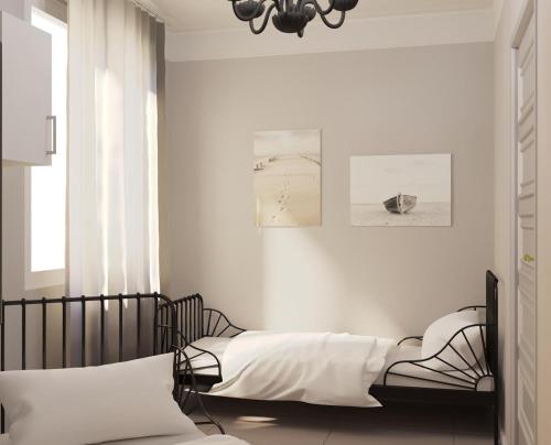 a bedroom with two beds and a chandelier at Apartment Via Alessandro Volta in Sanremo
