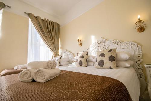 a bedroom with a bed with towels on it at Summerlands Guest House in Torquay