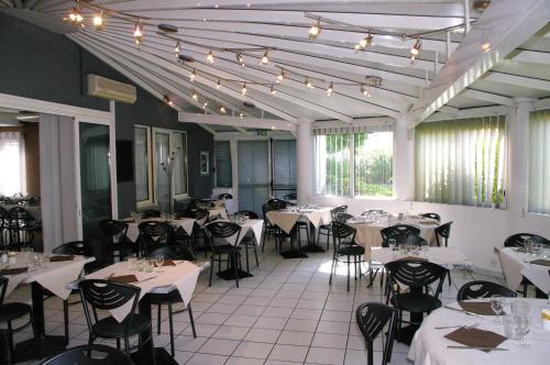 a restaurant with white tables and chairs and lights at Hotel du Moulin à Vent - Gerland in Vénissieux