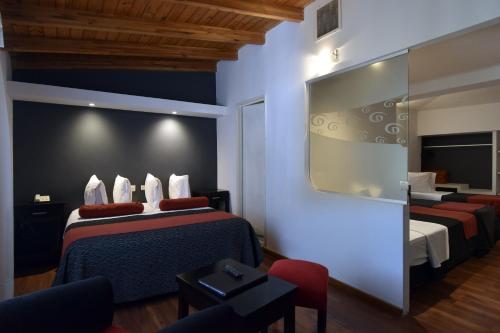 a hotel room with two beds and a mirror at Piazza Hotel in Villa Carlos Paz