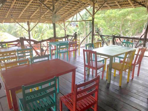 a group of tables and chairs on a deck at Harrera Perhentian, Long Beach in Perhentian Island