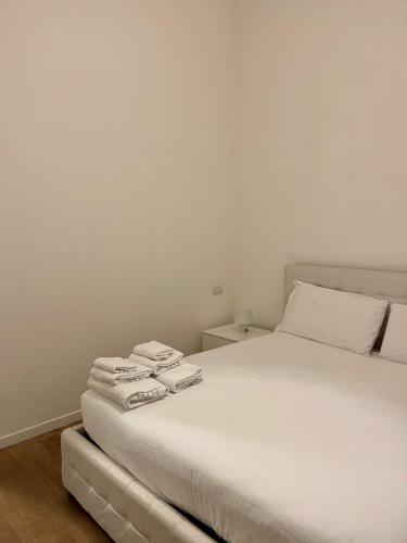 a bedroom with a white bed with towels on it at Easy Milano - Rooms and Apartments Navigli in Milan