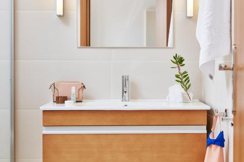 a bathroom with a sink and a mirror at Caldera Beach in Plataniás