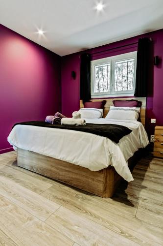 a bedroom with two beds with purple walls at La Maison Fratelli in Hyères