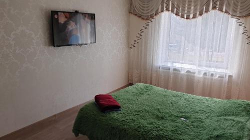 - une chambre avec un lit vert et une fenêtre dans l'établissement Apartament in chirie Moldova or.Soroca, à Soroca
