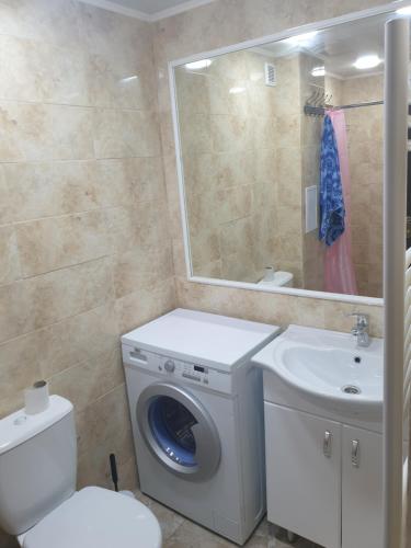 y baño con lavadora y lavamanos. en Apartament in chirie Moldova or.Soroca, en Soroca