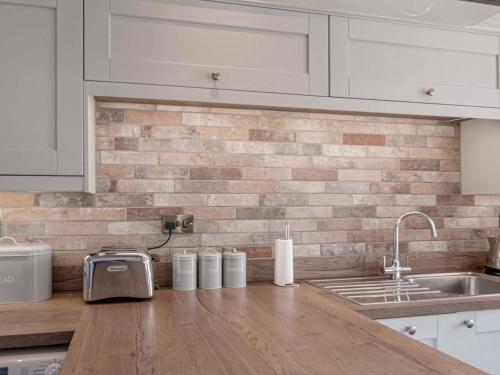 a kitchen with white cabinets and a counter with a sink at Crescent View in Buxton