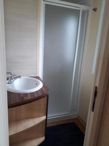 a bathroom with a white sink and a shower at Stacaravan 4pers in Bredene met eigen tuintje 2449 in Bredene