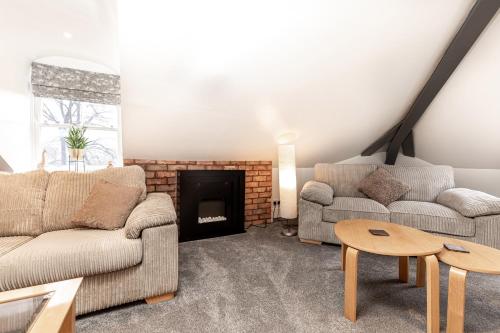 a living room with two couches and a fireplace at The Rooftop in Buxton