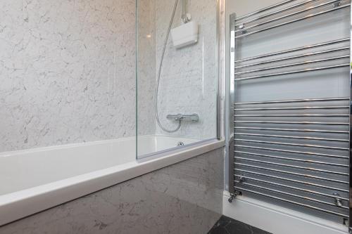 a bathroom with a tub and a glass shower at The Rooftop in Buxton