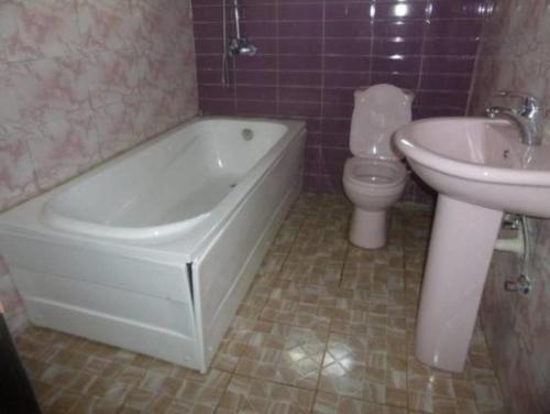 a bathroom with a tub and a toilet and a sink at Nera Hotels in Jabi
