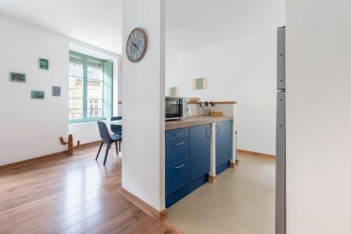 uma cozinha com um armário azul e um relógio na parede em My Colmar Homes - Le XIII em Colmar