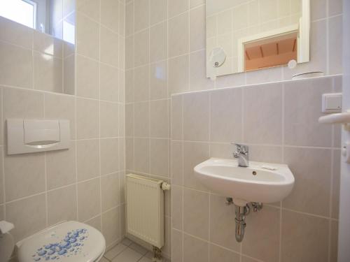 a bathroom with a toilet and a sink at Feriendorf Rugana - Komfort Appartement mit 2 Schlafzimmern und Terrasse C05 in Dranske