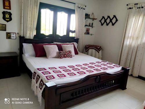 a bedroom with a large bed with a red and white blanket at Casa Campo Emaus in Caucasia