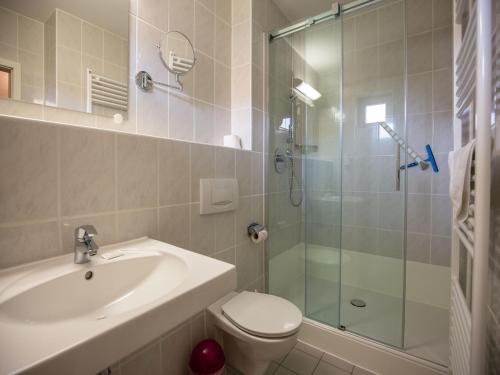 een badkamer met een douche, een toilet en een wastafel bij Feriendorf Rugana - Komfort Appartement mit 1 Schlafzimmer und Terrasse B52 in Dranske
