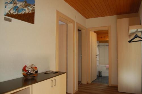 a room with a kitchen with a counter and a hallway at Akelei Apartments in Saas-Fee