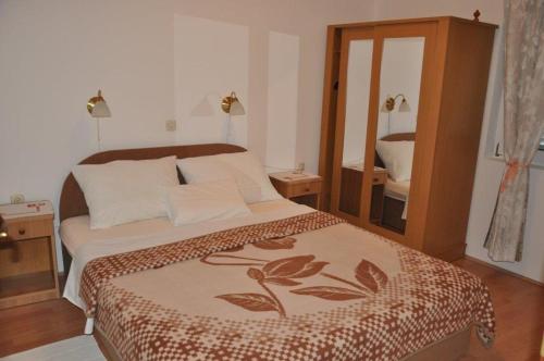 a bedroom with a large bed and a mirror at House Lopar (899) in Lopar