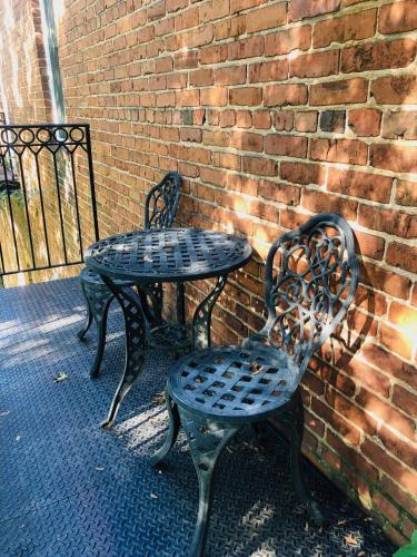 two metal tables and chairs next to a brick wall at Suites at 249 in Culpeper