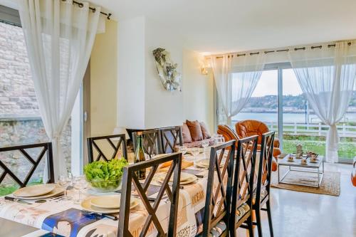 une salle à manger avec une table et des chaises et une fenêtre dans l'établissement Ker Paul et Ker Julien- appartements vue mer, à Erquy