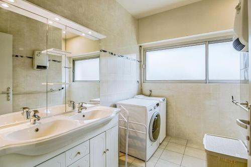 La salle de bains est pourvue d'un lave-linge et d'un lavabo. dans l'établissement Ker Paul et Ker Julien- appartements vue mer, à Erquy