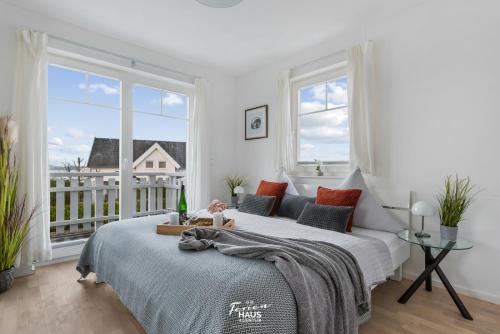 a bedroom with two beds and a balcony at Havlyst in Olpenitz