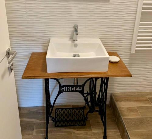 um lavatório branco numa mesa de madeira na casa de banho em Il Parco - Alloggio Eva em La Spezia
