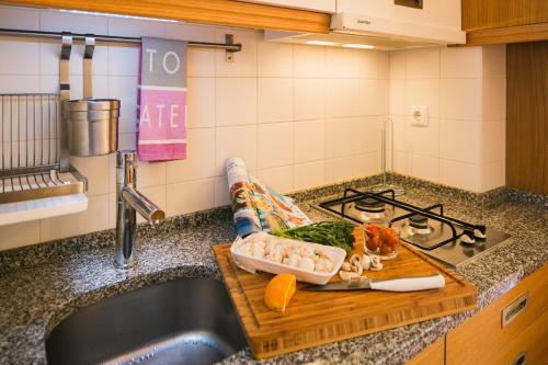リスボンにあるCharm and Comfort Apartment 46 by Lisbonne Collectionのキッチンカウンター(野菜の入ったまな板付)