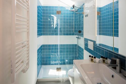 リスボンにあるCentral Modern and Bright Rooftop Apatment 59 by Lisbonne Collectionの青いタイル張りのバスルーム(トイレ、シンク付)