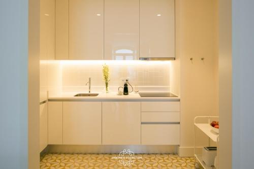 リスボンにあるDowntown Sleek Apartment 65 by Lisbonne Collectionの白いキャビネットとシンク付きのキッチン