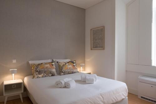 リスボンにあるDowntown Sleek Apartment 65 by Lisbonne Collectionのベッドルーム1室(白いベッド1台、タオル付)