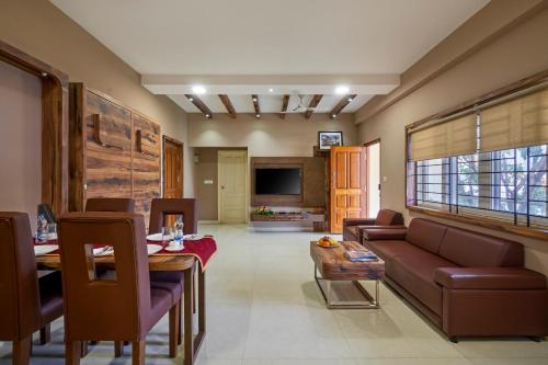 - un salon avec un canapé et une table dans l'établissement Sanctum Luxury Serviced Apartments, à Chikmagalur