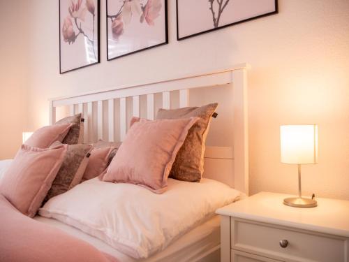 une chambre avec un lit avec des oreillers roses et blancs dans l'établissement EUPHORAS - Modern eingerichtete Ferienwohnung mit 3 Schlafzimmern im Harz, à Clausthal-Zellerfeld