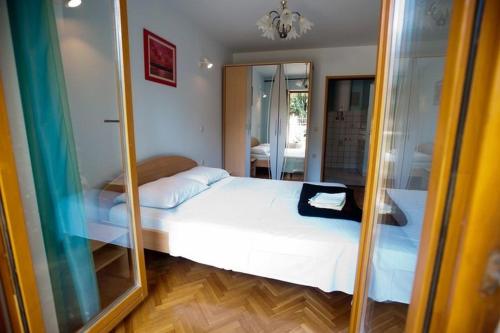 um quarto com uma cama branca e um espelho em One-bedroom apartment with terrace in Povile 3542-3 em Povile