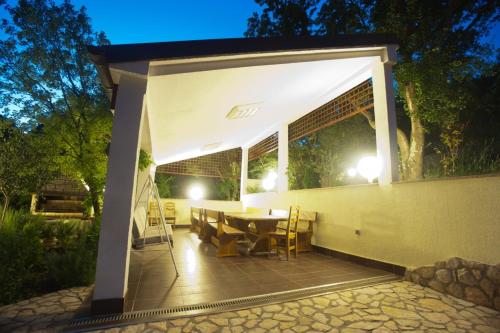 a pavilion with a table and chairs on a patio at night at One-bedroom apartment with terrace in Povile 3542-3 in Povile