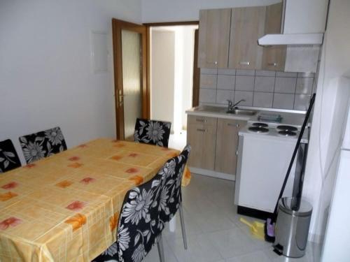 a kitchen with a table and chairs in a room at Apartment in Palit with sea view, balcony, Wi-Fi (4606-3) in Mundanije