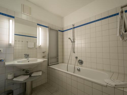 uma casa de banho com uma banheira, um lavatório e um chuveiro em Kaiservillen Heringsdorf - Ferienwohnung mit 1 Schlafzimmer und Balkon D214 em Heringsdorf