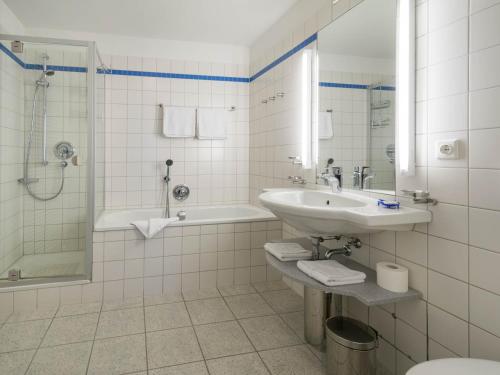 une salle de bain avec un lavabo, une baignoire et une douche dans l'établissement Kaiservillen Heringsdorf - Ferienwohnung mit 1 Schlafzimmer und Balkon D221, à Heringsdorf