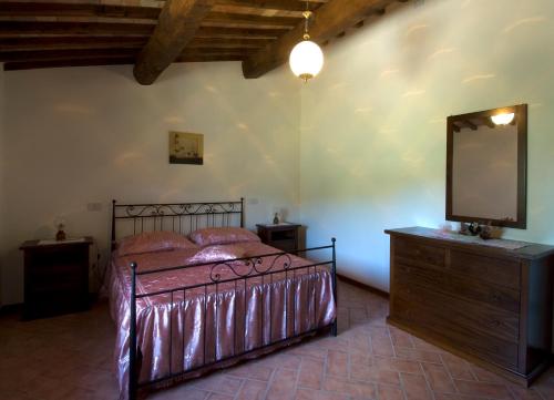 a bedroom with a bed and a mirror and a dresser at Casa il Ponte in Chianni