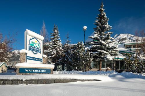 a sign in the snow in front of a hotel at Pocaterra Inn & Waterslide in Canmore