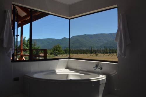 a bath tub in a bathroom with a large window at Eco Hotel Antuco in Antuco