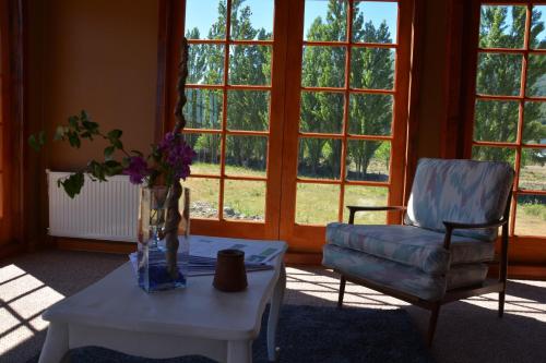 a living room with a table and a chair and a vase of flowers at Eco Hotel Antuco in Antuco