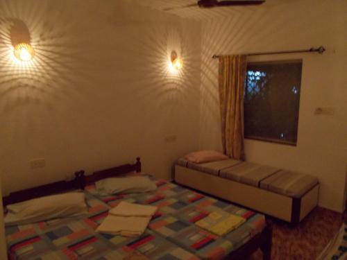 Un dormitorio con dos camas y una ventana. en Arjun Villa Guest House, en Anjuna