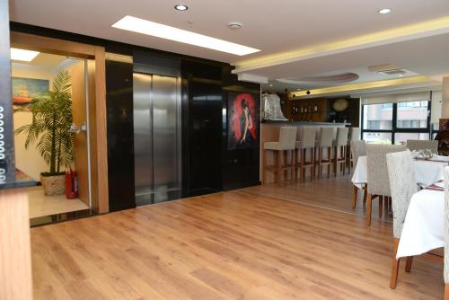 a dining room with wooden floors and white tables and chairs at NK Hotel in Izmir